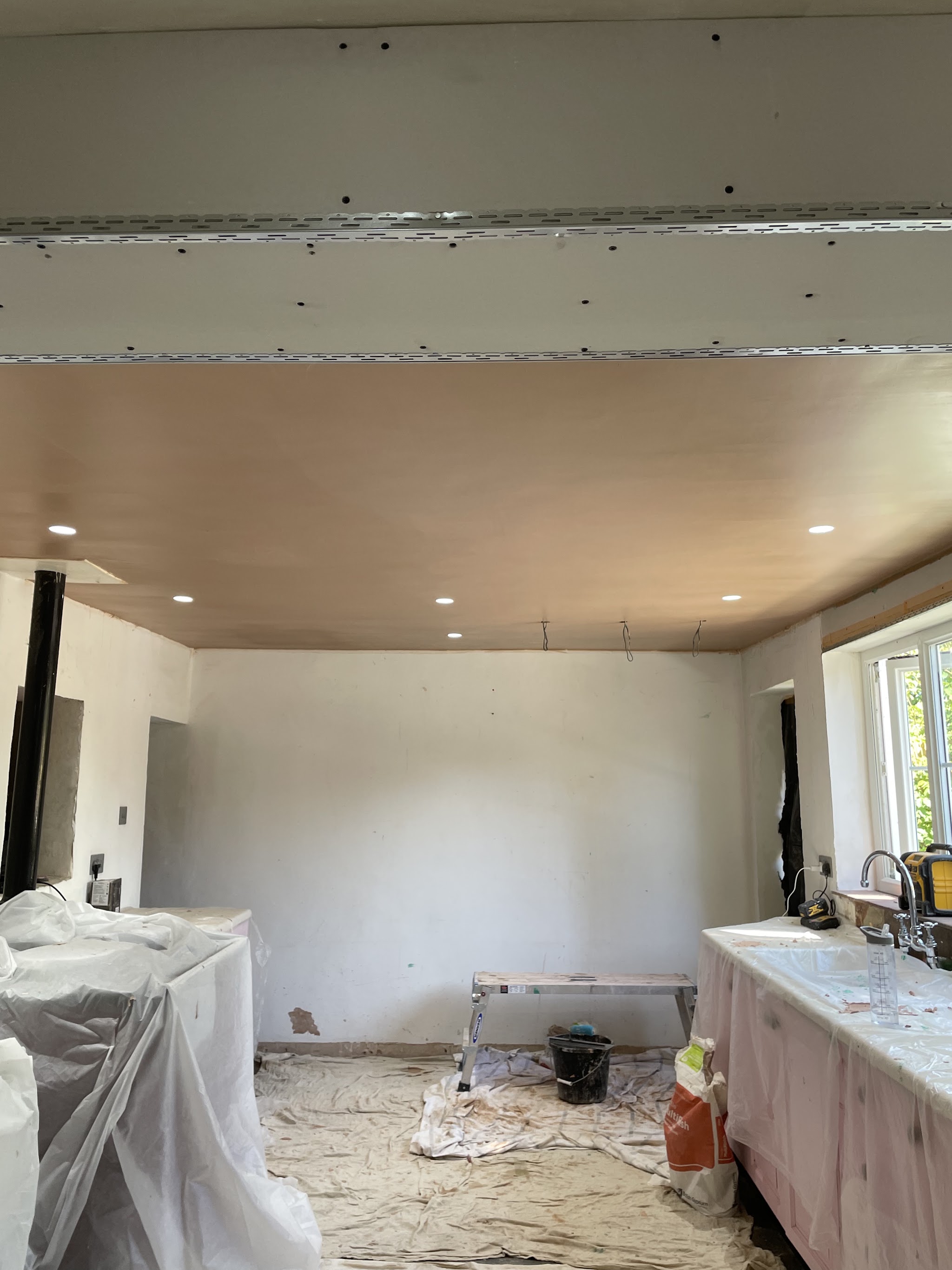 Kitchen ceiling freshly plastered with dust sheets down