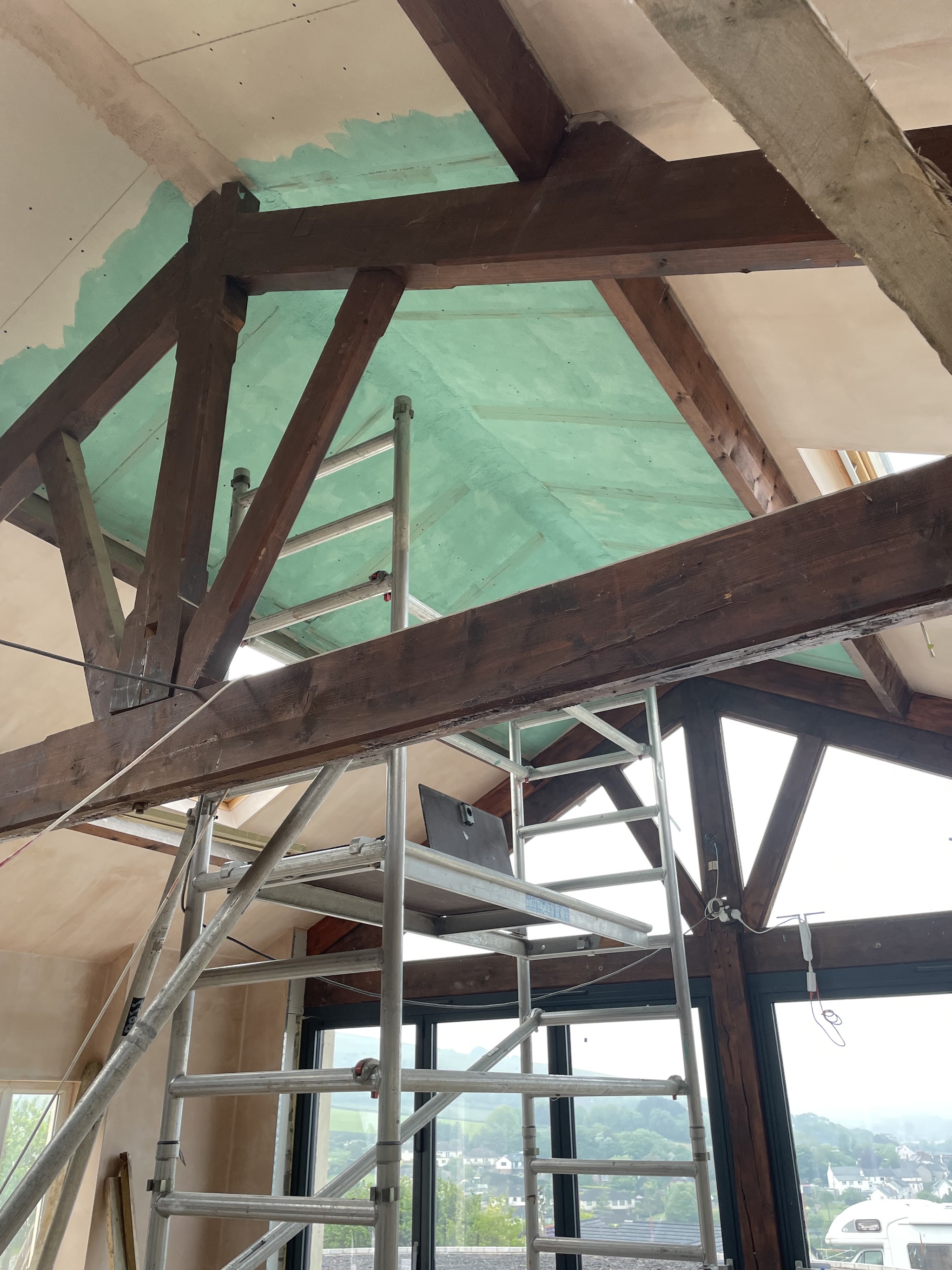High vaulted ceiling with a scaffold tower and exposed beams